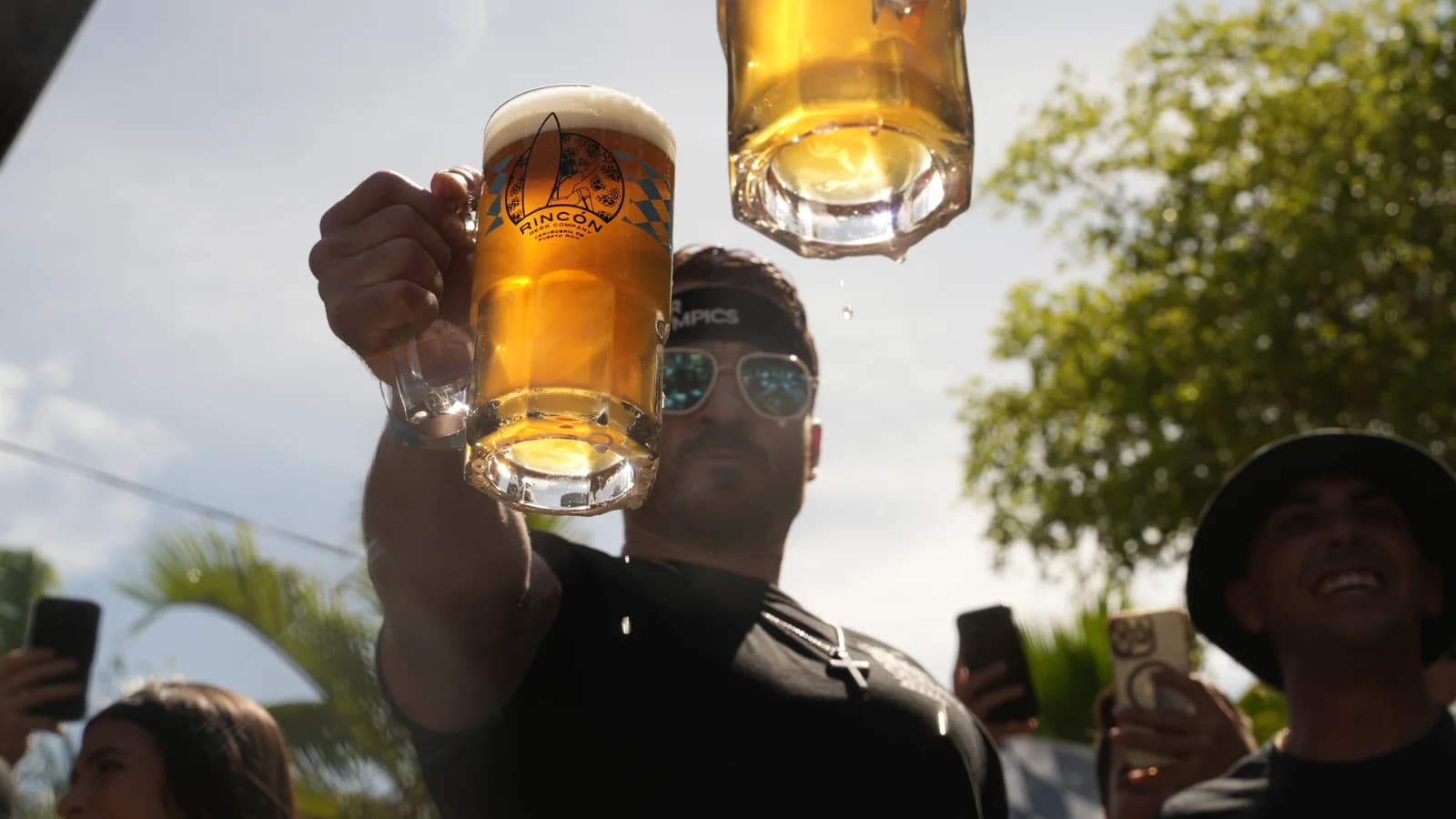 Brindis con jarra Rincón Beer Company en alto durante Beer Olympics, Plaza de Rincón